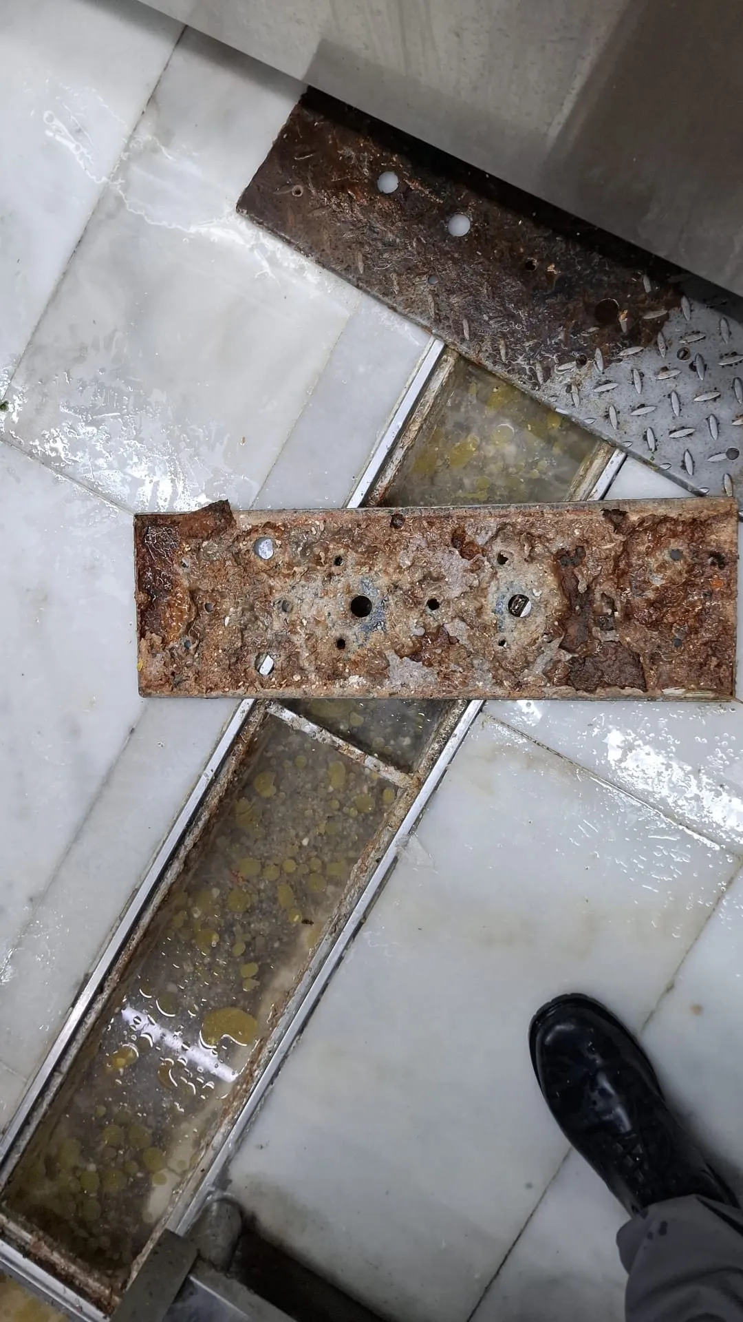 起出後廚地渠蓋，可見積聚的油污與鏽蝕